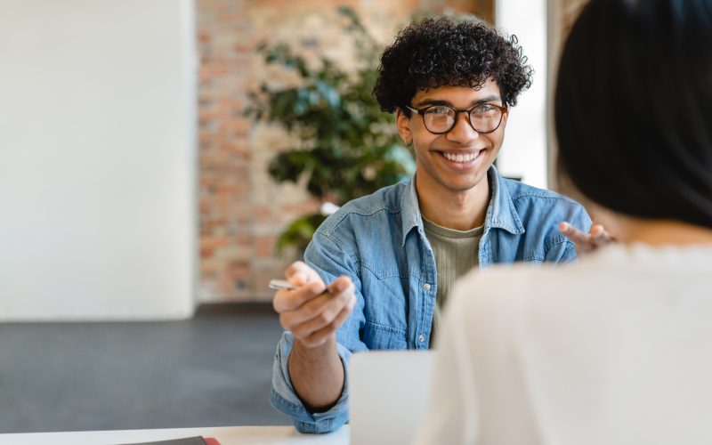 Successful young colleagues having negotiation at the working desk in office