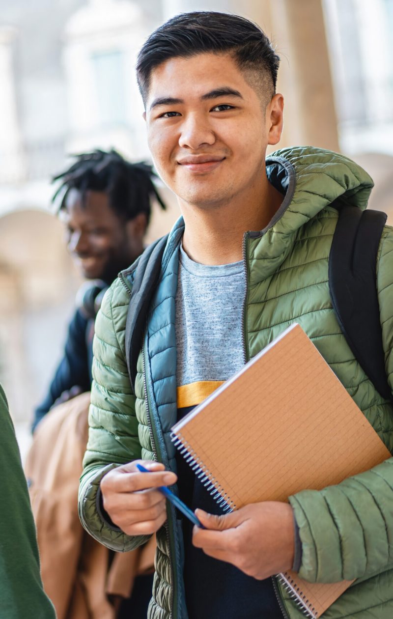 Cheerful diverse students with books and backpacks share a joyful moment, embodying friendship and diversity.
